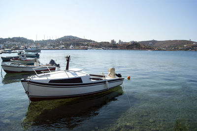 Sailboats moored in sea against clear sky