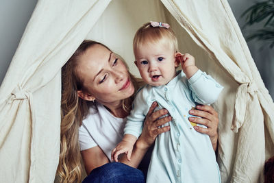 Mom and 1-year-old daughter spend time together at home.