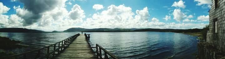 Pier on sea against cloudy sky