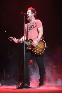 Young man holding guitar at night