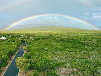 Scenic view of rainbow over landscape against sky