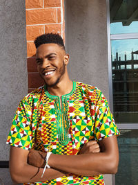 Portrait of young man standing against wall