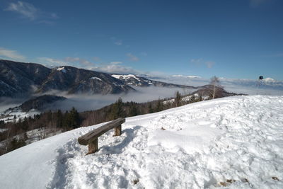 High angle view of wooden bench on snowcapped mountain during winter