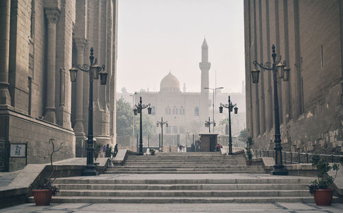 People walking on street amidst buildings in city