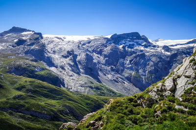 Scenic view of snowcapped mountains against clear blue sky