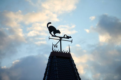 Low angle view of birds on cloudy sky