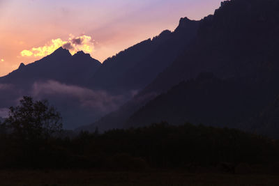 Scenic view of silhouette mountains against sky at sunset