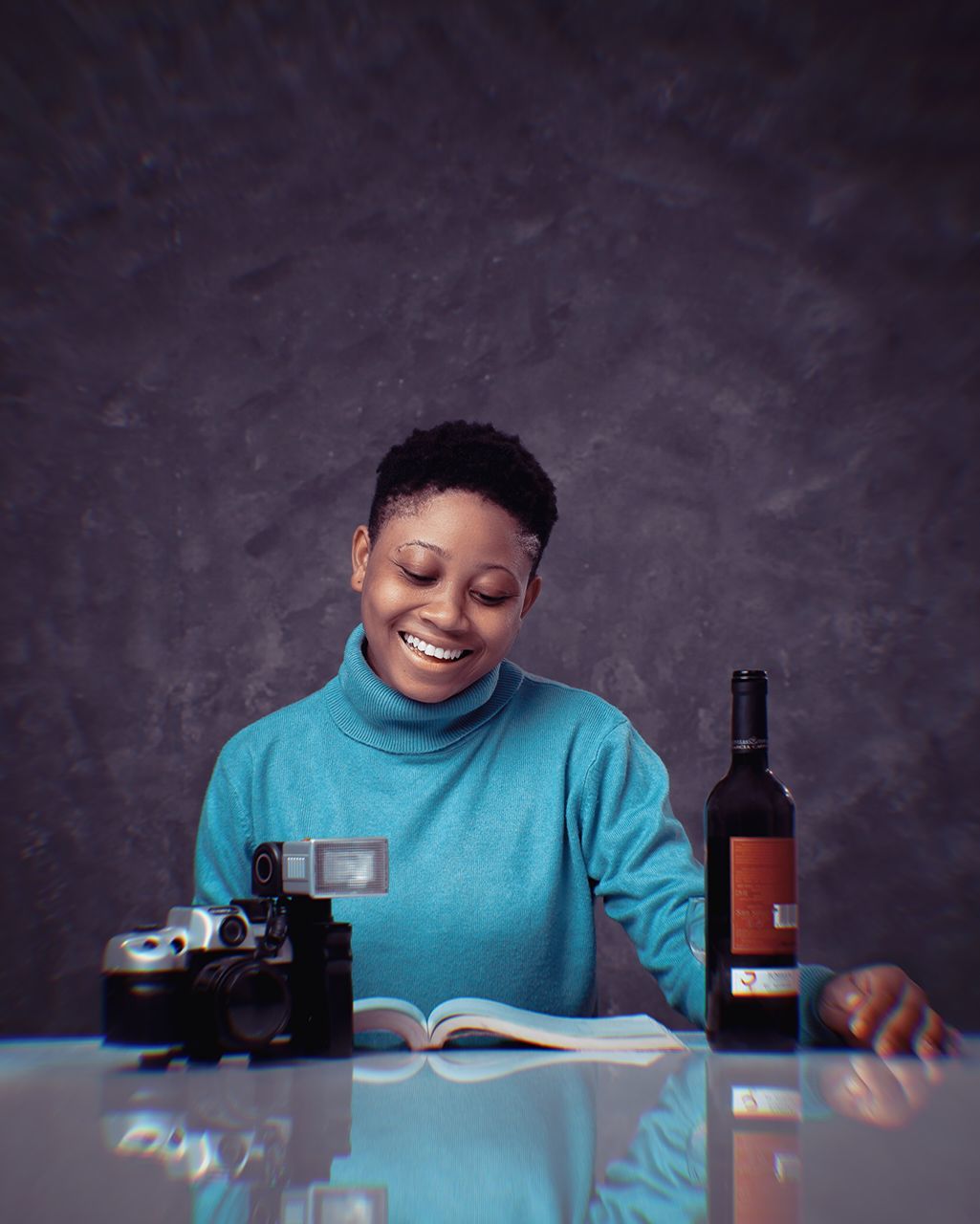 bottle, blue, one person, smiling, happiness, adult, person, emotion, technology, portrait, indoors, cheerful, table, drink, young adult, men, copy space, occupation, enjoyment, waist up, refreshment, food and drink, holding, fun, front view, sitting, human face, container, clothing, communication, lifestyles, wireless technology, casual clothing