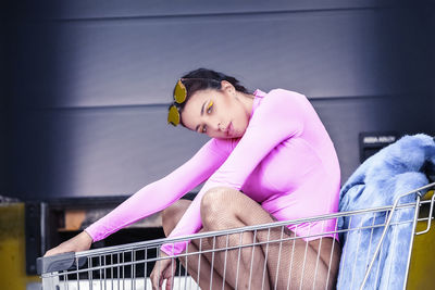 Portrait of woman sitting in shopping cart