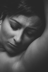 Close-up of shirtless young woman with eyes closed