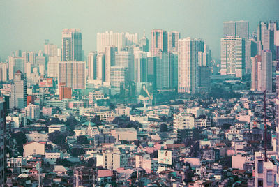 Aerial view of buildings in city against sky