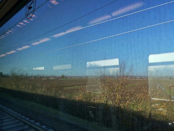 Train on railroad track seen through window