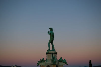 Low angle view of statue against sky during sunset