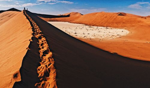 Sand dunes in desert against sky