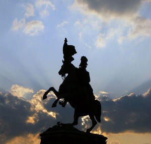 Low angle view of silhouette statue against sky during sunset