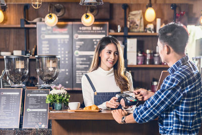 Young woman holding drink in restaurant