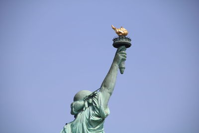 Low angle view of statue of liberty against blue sky