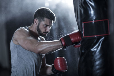 Boxer exercising with punch bag