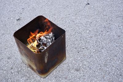 High angle view of papers burning in garbage bin on road