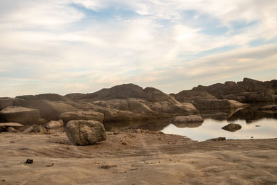 Scenic view of rocks on beach against sky