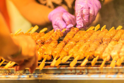 Midsection of person preparing food on barbecue