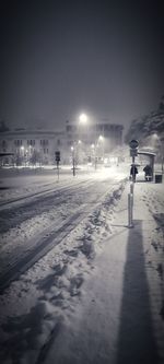 People walking on snow covered street at night