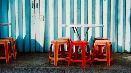 Empty chairs and tables against blue wall