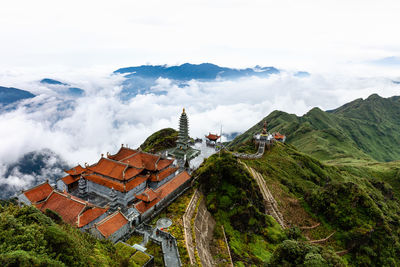 Aerial view of temple on cliff against cloudy sky