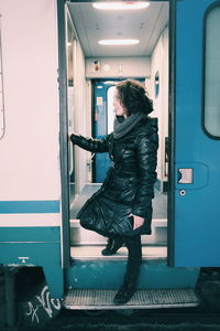 Side view of woman standing in train