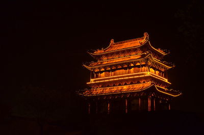 Low angle view of illuminated building against sky at night