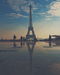 Eiffel tower against cloudy sky during sunset