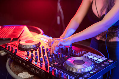 Close-up of woman playing music on audio equipment in nightclub