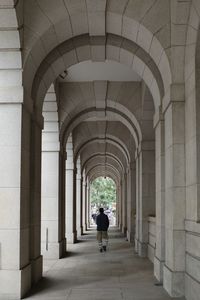 Rear view of man walking in tunnel