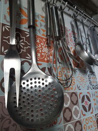 Close-up of kitchen utensils hanging on wall at home