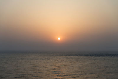 Scenic view of sea against orange sky