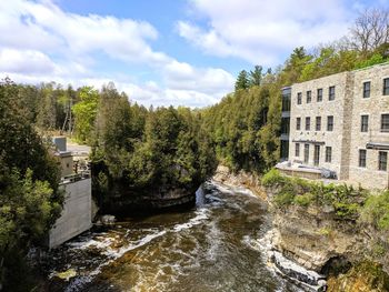 River amidst trees and buildings against sky