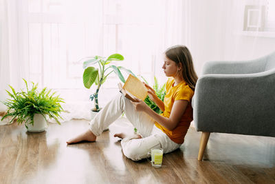 Portrait of woman sitting on sofa at home