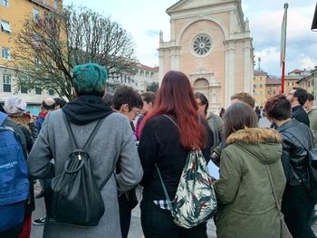 Rear view of people standing in city