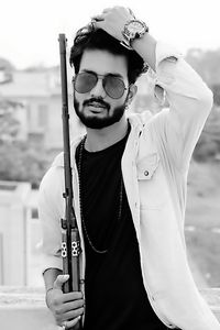 Portrait of young man wearing sunglasses standing outdoors