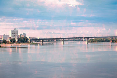 Scenic view of lake by buildings against sky