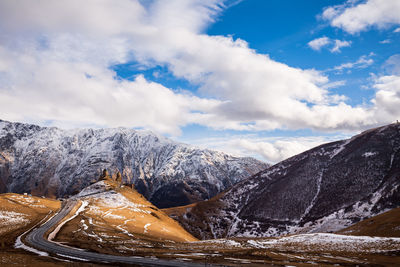 Scenic view of snowcapped mountains against cloudy sky