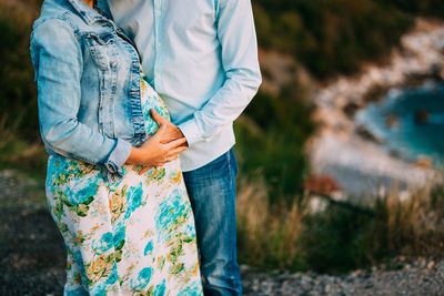 Midsection of couple standing on field