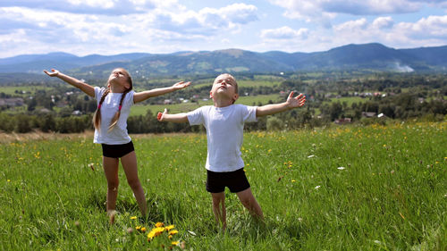 Happy friends enjoying on field against sky