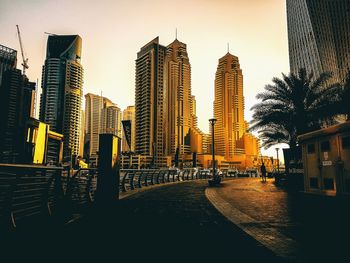 Street amidst buildings during sunset