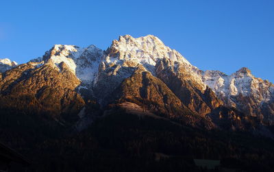 Low angle view of mountains against clear blue sky