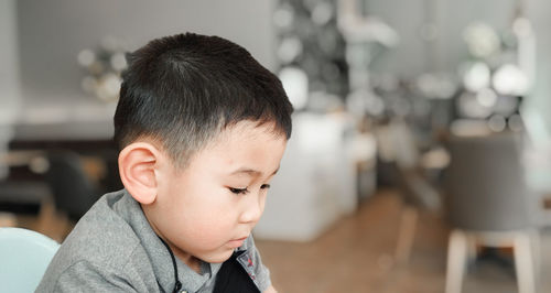Close-up portrait of boy looking at home