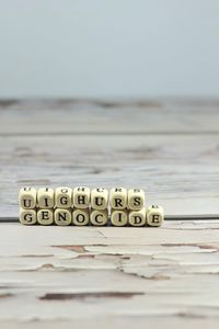 Close-up of text on table against sea