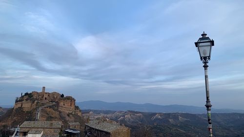 Street light by building against sky