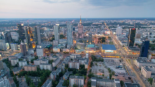 Illuminated cityscape against sky at dusk