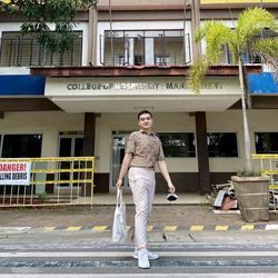 A whole body of man standing behind a building 